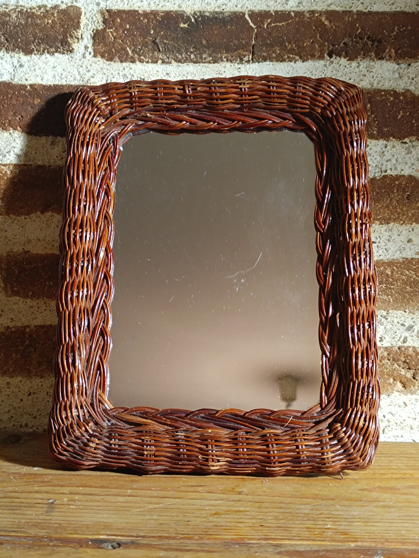 Miroir en rotin teinté et tressé.